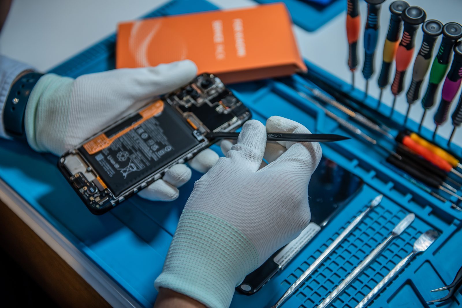 Técnico certificado reparando smartphone con herramientas de precisión